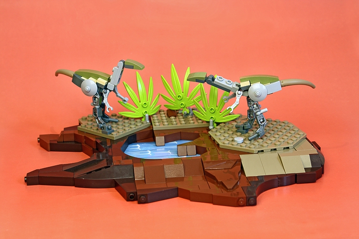 LEGO MOC - Jurassic World - Sunset: <p align=left></i>Вожак стоял неподвижно, и только подрагивающий кончик хвоста выдавал напряжение. Он прислушивался к звукам, раздававшимся из зарослей. Это несколько самцов и самок с молодняком – вся немногочисленная стая – пробирались сквозь кусты. Стая была истощена. В последнее время совсем мало попадалось добычи. Несколько сумчатых, пойманных накануне, забрали много сил и совсем не имели питательной ценности. Необходимо было уходить и искать другие места для охоты, а это значит подвергать стаю новым опасностям. Вожак посмотрел на ящера, стоящего рядом – этот молодой самец уже давно хочет занять его место, и, рано или поздно, он или другой из стаи сделает это... Но сегодня стая получит еду! Старый динозавр уже давно заметил след, оставленный гигантским тираннозавром в грязи. Исполин прошел здесь только вчера, вмятина от его огромной ноги еще не успела затянуться, а только наполнилась водой. Стая сможет пойти по следу гиганта и вскоре наткнется на остатки его пиршества. <br><br><br />
Вожак клацнул зубами, скорее для того, чтобы отогнать мошкару, изогнул шею и издал шипящий звук, затем быстро направился в кусты. За ним последовал и второй динозавр. Послышался звук удаляющихся шагов, и через минуту все стихло. Солнце клонилось к закату.  <br />
<br><br><br />
<p align=right><i> Записки неизвестного палеонтолога